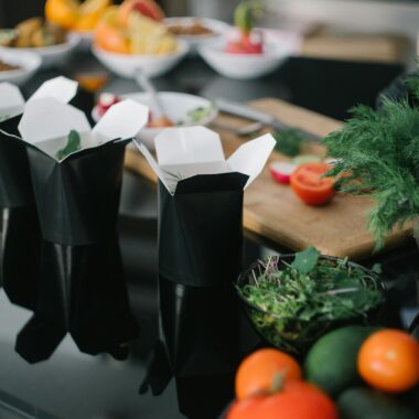 A selection of fresh vegetables and takeout boxes for a healthy meal option.