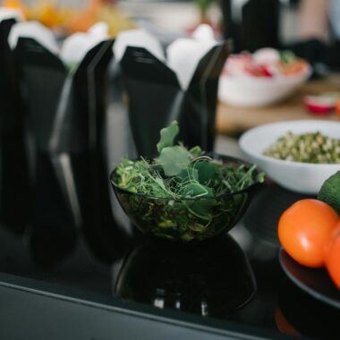 Close-up of fresh vegetables and takeout containers in a kitchen setting.